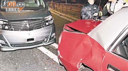的士車尾箱被撞損毀，七人車司機（左）在場協助警方調查。（周宏杰攝）