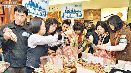 數十名參加年貨旅行團的內地旅客在本港商場購買年貨。	