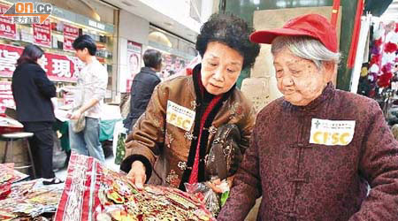 黃紹華（右）與女兒（左）買新年裝飾品，女兒耐心地向母親講解。	（林少權攝）