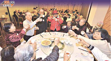 防止虐待長者協會邀請逾百名長者吃團年飯，大家舉杯暢飲。	（黃仲民攝）