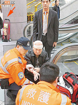 跌傷男子接受急救，義肢及手推車放一旁（箭嘴示）。	（陳展鴻攝）