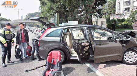 七人車司機（左二）向在場警員講述事發經過，地上的則為車上的嬰兒座位。	（蕭添榮攝）