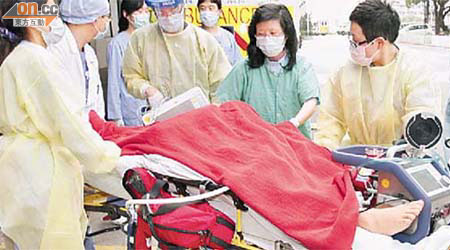 全副防護裝備人員將瑪嘉烈豬流感病人運送往瑪麗醫院。（劉子文攝）
