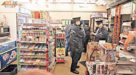 警員在遇劫的便利店內調查。	（郭垂垂攝）