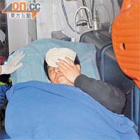 聲稱被內地客打傷的導遊陳先生在救護車上治理。