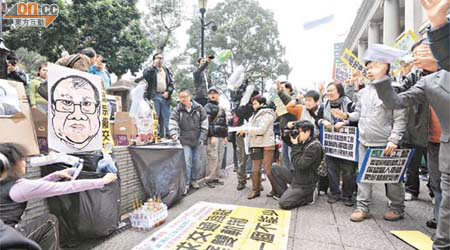 示威者向曾蔭權及張建宗肖像上香及掟膠樽，諷刺兩人「不食人間煙火、不知米貴」。	（袁志豪攝）