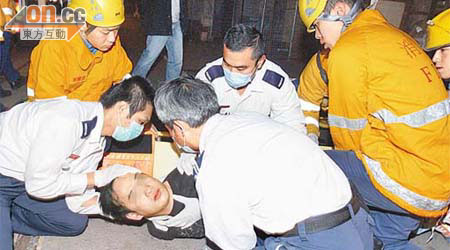 救護員為跳樓受傷青年包紮。	（張曉楠攝）