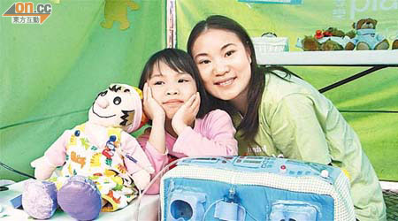 青年大使馮禕與同患腎衰竭的女兒，替公仔玩洗腎遊戲。