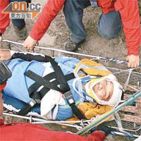 救援人員用「山兜」運載傷者上山。
