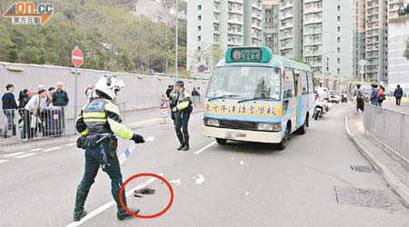 警員在小巴撞傷女學生現場調查，路中遺下被剪下的一撮長髮（圓圈示）。	（林少兒／郭錦良攝）