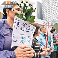 有請願者手持白菊花悼念日本死難者。