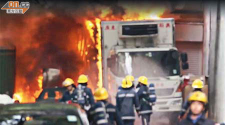 起火凍櫃車陷入火海，消防員在場撲救。	（讀者提供）
