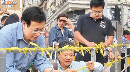 養和醫院重建關注組成員及區議員在養和醫院外綁黃絲帶，要求城規會仔細考慮院方擴建計劃對居民的影響。