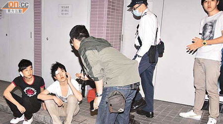 遇劫遭打傷的青少年（左一及左二）向探員講述經過，圖右為同行友人。	（林振華攝）
