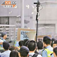 社民連代表焚燒新華社對艾未未的報道，警員隨即用滅火器將火噴熄，隨後示威者將溪錢擲向中聯辦。