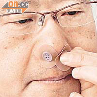 劉桂強示範如何將正氣壓鼻貼貼上兩鼻孔。	（鍾麗珊攝）