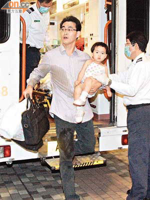 林醫生抱着長女前往醫院。（胡德威攝）