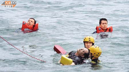 消防蛙人將男浮屍撈起。	（林少兒攝）