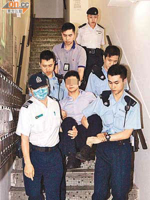 被捕男子被四名警員及一名救護員抬走。 	（梁國雄攝）