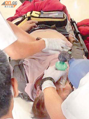 救護員將昏迷的士司機送院時，為他施以心外壓急救。（黃君堡攝）