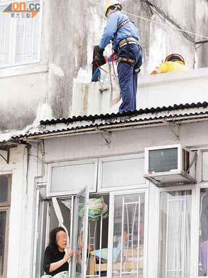 內地婦人危坐窗邊，消防員正設法營救。	（梁少恒攝）