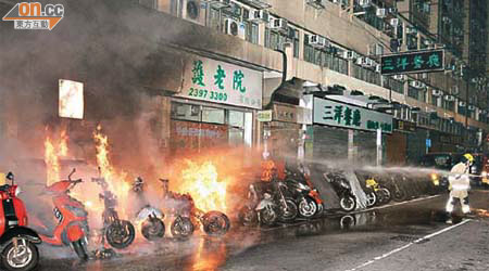 大全街火燒電單車，消防員射水灌救。	（周宏杰攝）