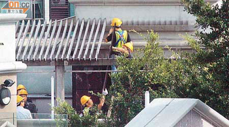數名工人昨午閃電拆除京士柏山道十八號天台加建部分。	（蘇文傑攝）