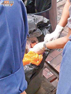 警員檢查膠袋內的嬰屍。	（吳欽旺攝）