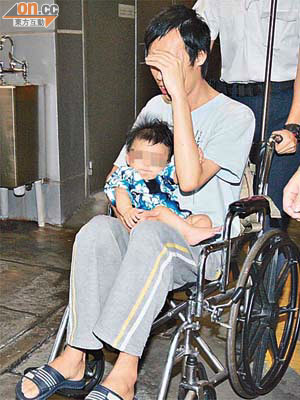 疑被虐打的男嬰由父親抱着送院。（高偉明攝）
