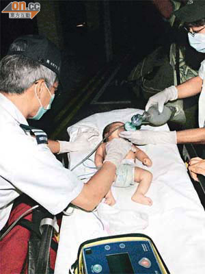 嬰兒送院時面色發紫，救護員為他急救，惜最終不治。	（林振華攝）