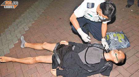遭童黨打傷的男子，由救護員檢查傷勢。	（楊日權攝）