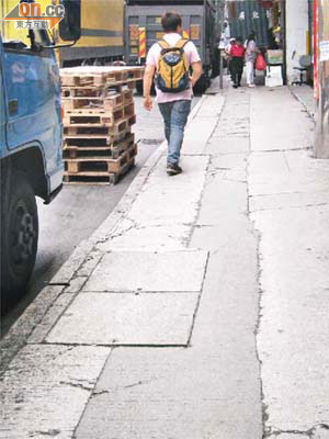 觀塘駿業街行人路疑因常有鏟車上落貨，導致路面不平，影響行人安全。