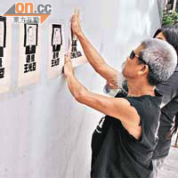 社民連成員在酒店外的建築物外牆上，貼上畫有王光亞畫像、寫着「通緝王光亞」的海報。