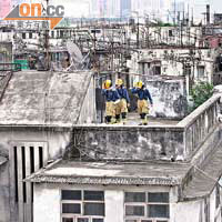 消防員在火場大廈天台調查。	（陳錦昌攝）