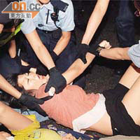 警員將一名躺在地上的女示威者抬離馬路。	（麥潤田攝）