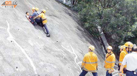 消防員游繩將被困男童救落斜坡底。	（梁卓明攝）