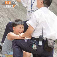 保安員冒險爬落斜坡扶住因被困而驚慌大哭的男童。