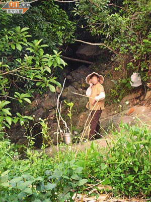 有「農婦」在溪邊準備打水。
