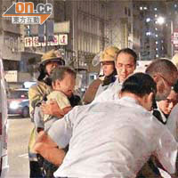 婦人女兒被帶上警車，兒子由警員手抱照顧。