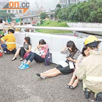 受傷乘客坐於天橋壆邊等候救援。