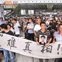 遇難者家屬手拉橫額在溫州火車南站示威。