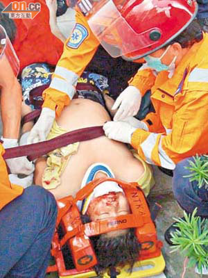 受傷工人戴上頸箍及氧氣罩送院。	（譚威權攝）