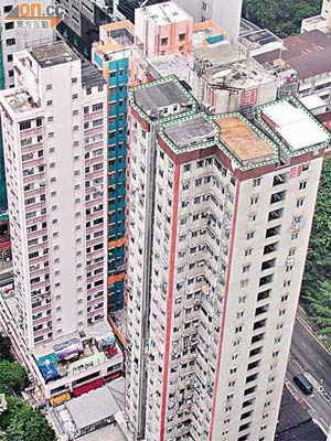 天台被發現有多個僭建物（箭嘴示），與鄰近私樓空蕩蕩的天台頓成強烈對比。