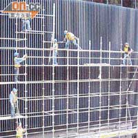 工人仍在為新大樓外牆工程趕工，部分工人未有扣上安全帶。