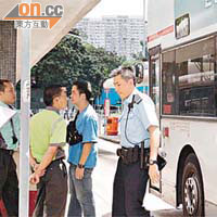 巴士車長（中）在總站協助警方調查。