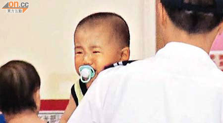 男嬰由救護員抱送醫院時仍痛楚大哭。	（黃君堡攝）