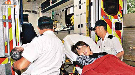 在家產子的少女由救護員連同男嬰送院。	（邱國賢攝）