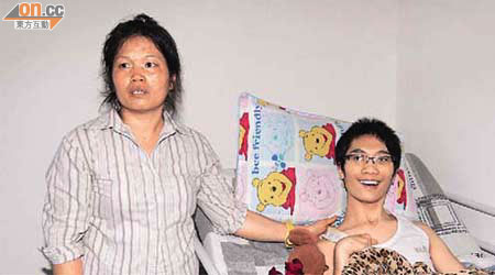 案中被打至癱瘓的青年李廣彬（右）現時由母親（左）照顧一切起居飲食。	（朱先儒攝）