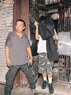 被捕逆子（右）被警員帶署調查。	（楊偉嶽攝）