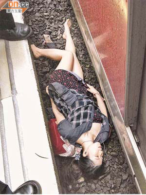 墮軌<br>女事主從月台空隙跌下路軌，受傷倒臥路軌旁。 	（李國健攝）